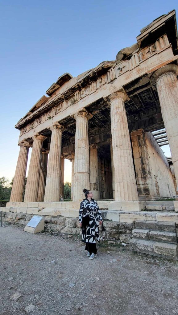 Me standing in front of the temple at the ancient agora in athens, one of the most instagrammable places in athens