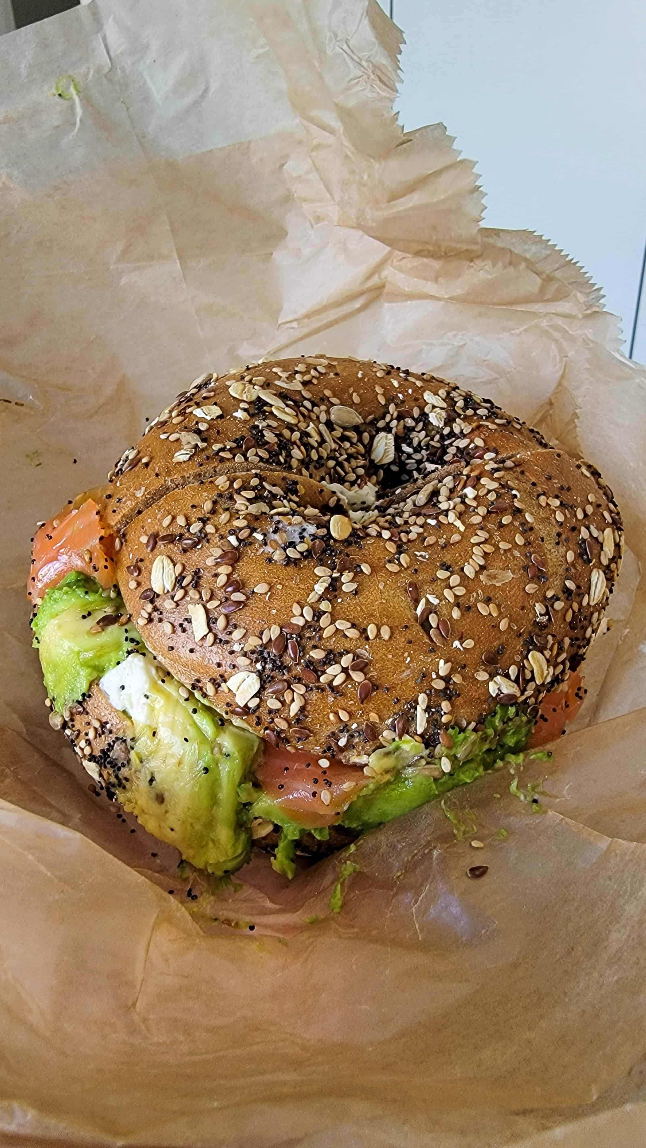 a multigrain bagel with smoked salmon avocado tomato and cream cheese