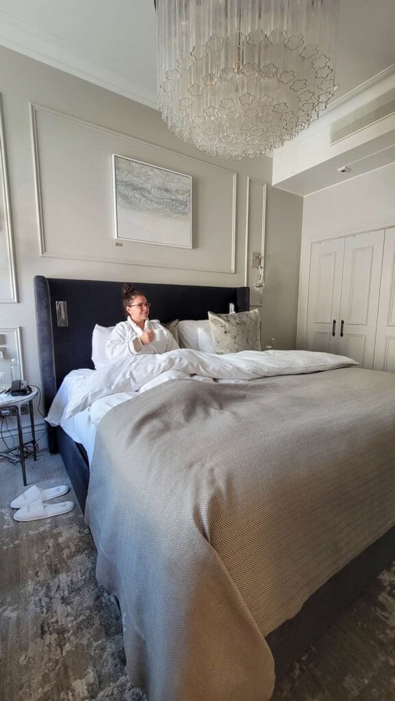 the author in bed at the waldorf astoria, in the best neighborhood to stay in helsinki