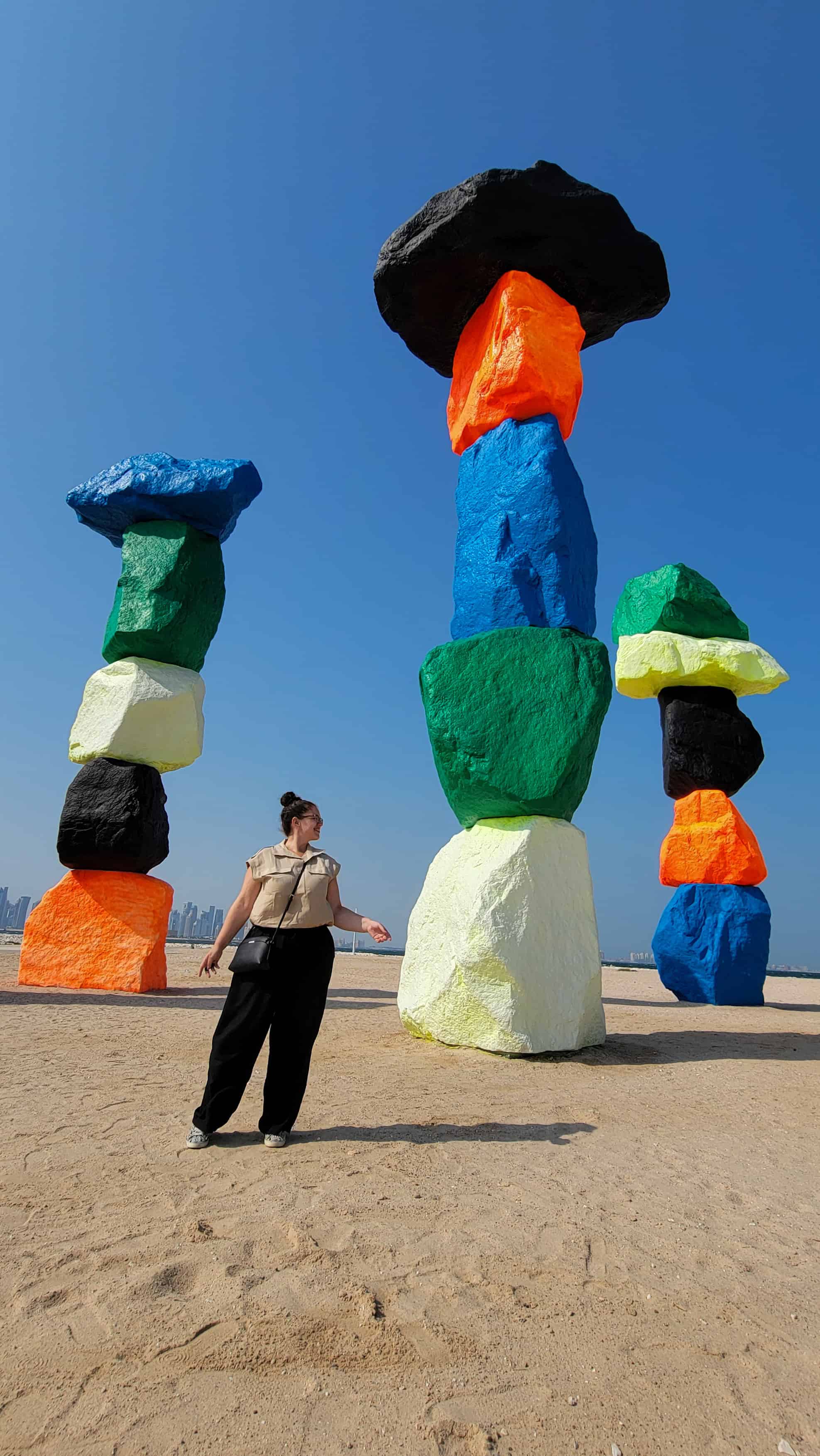 the author in front of a colorful sculpture in doha