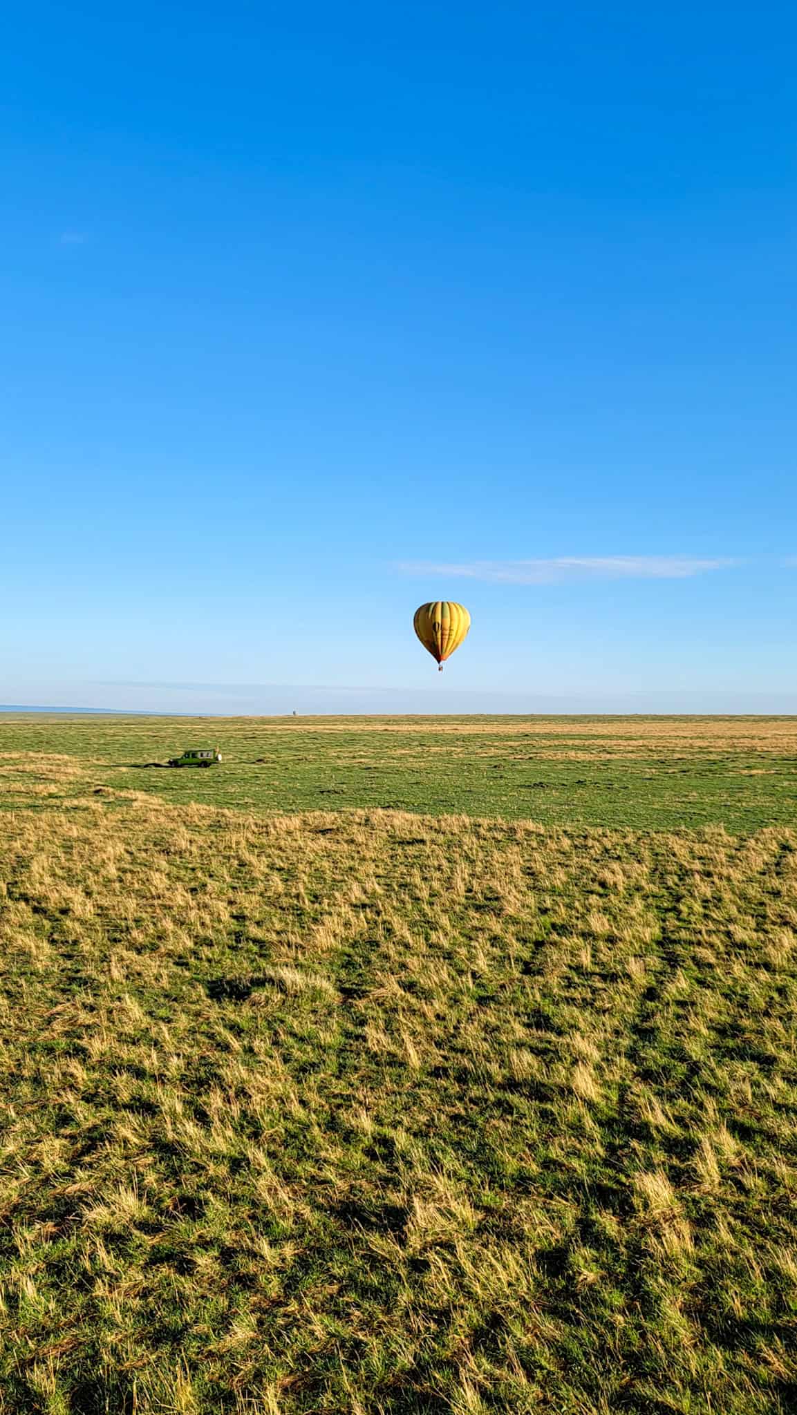 a hot air balloon and a jeep in the maasai mara