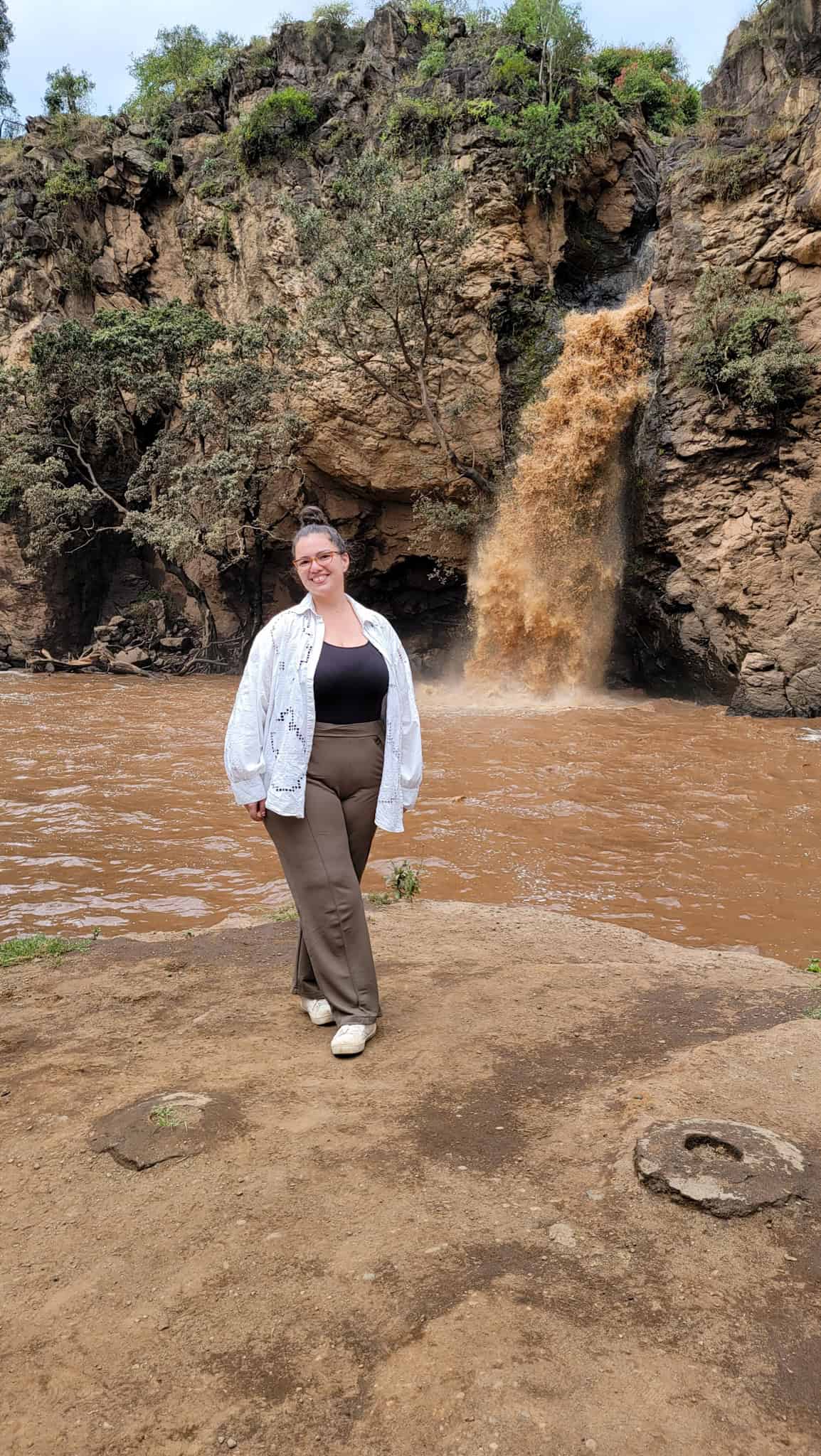 the author by a waterfall in kenya