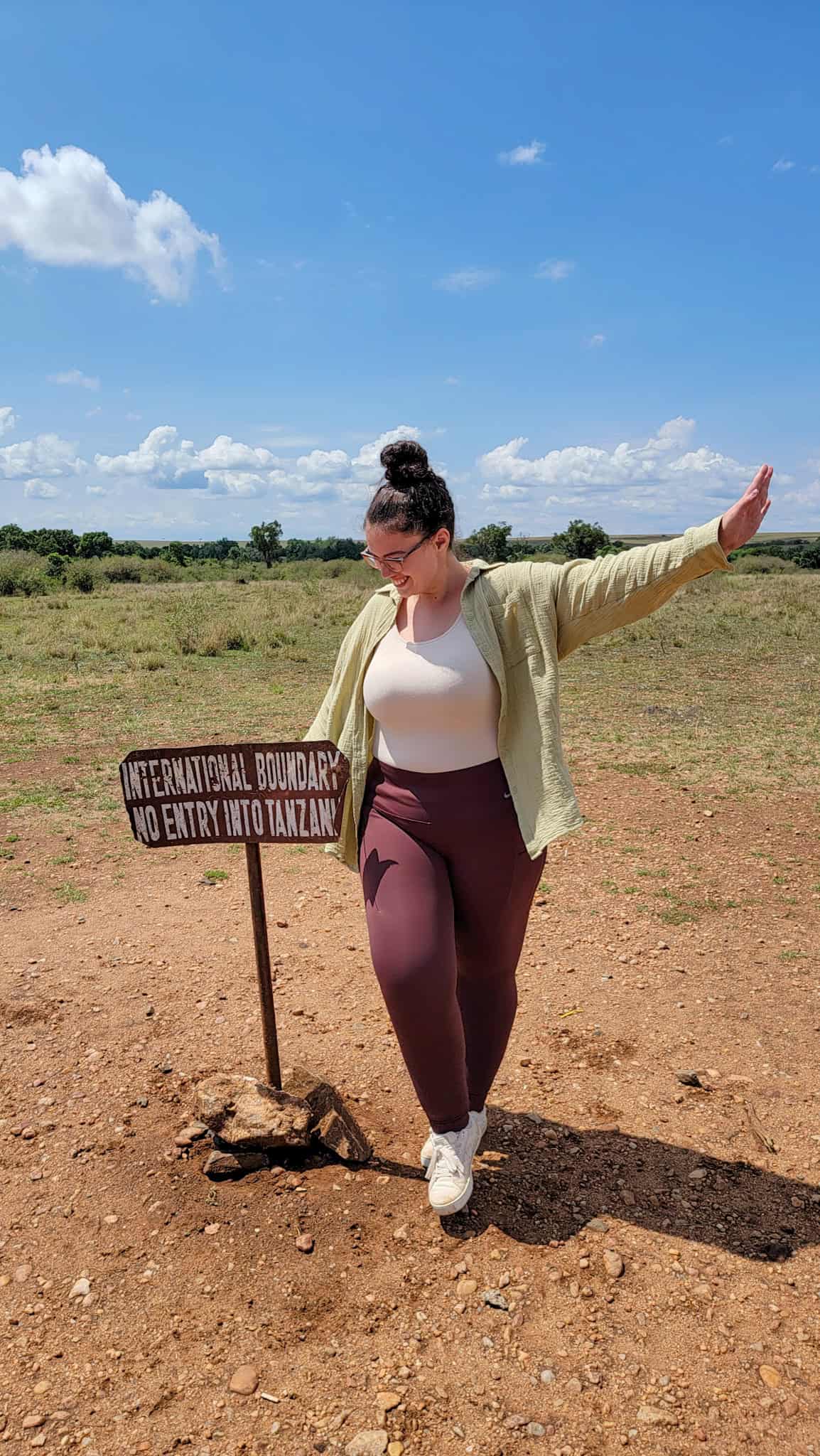 the author by the sign for the border between kenya and tanzania