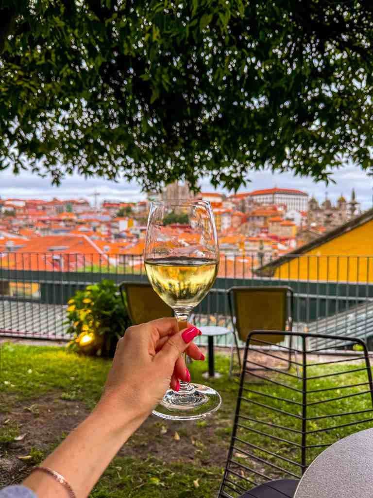 a glass of wine and the view from bar rooftop flores in porto