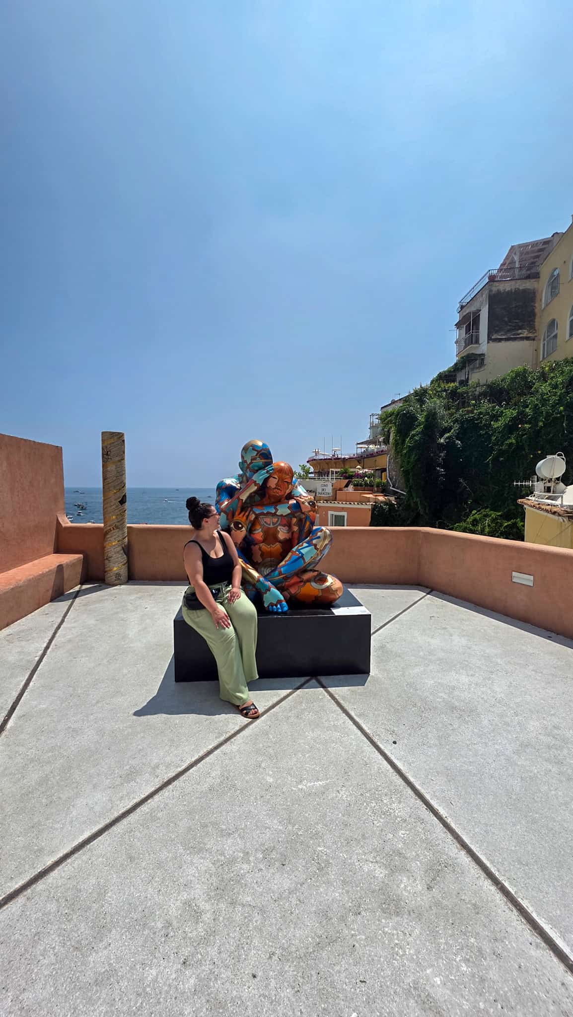 the author and the statue next to the church of santa mara assunta in positano