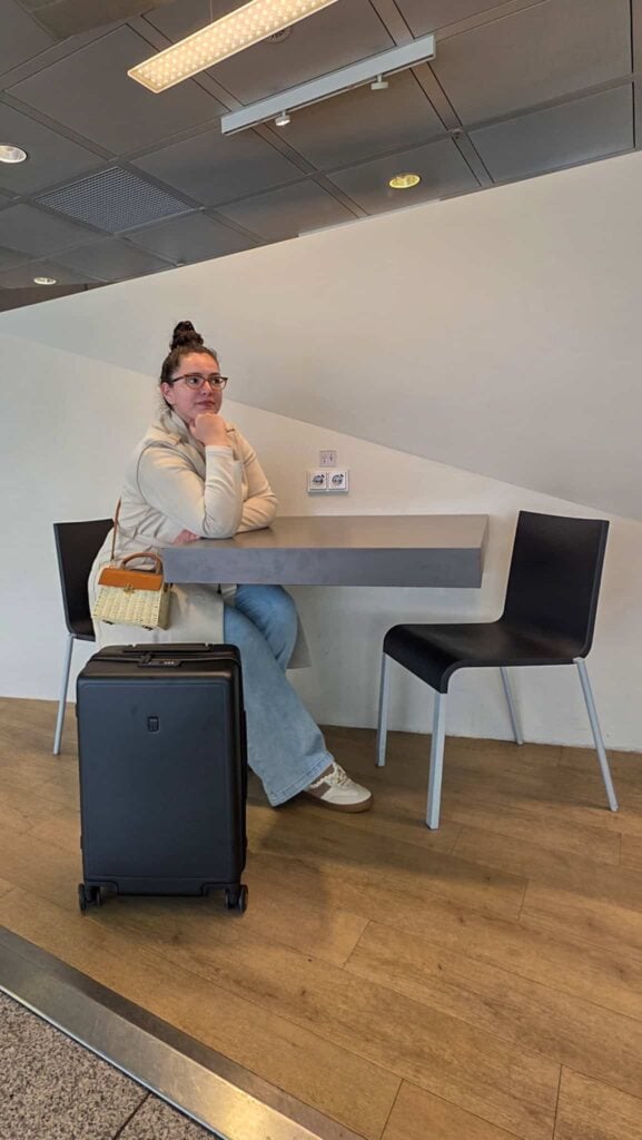 the author sitting down at the airport with her LEVEL8 luggage