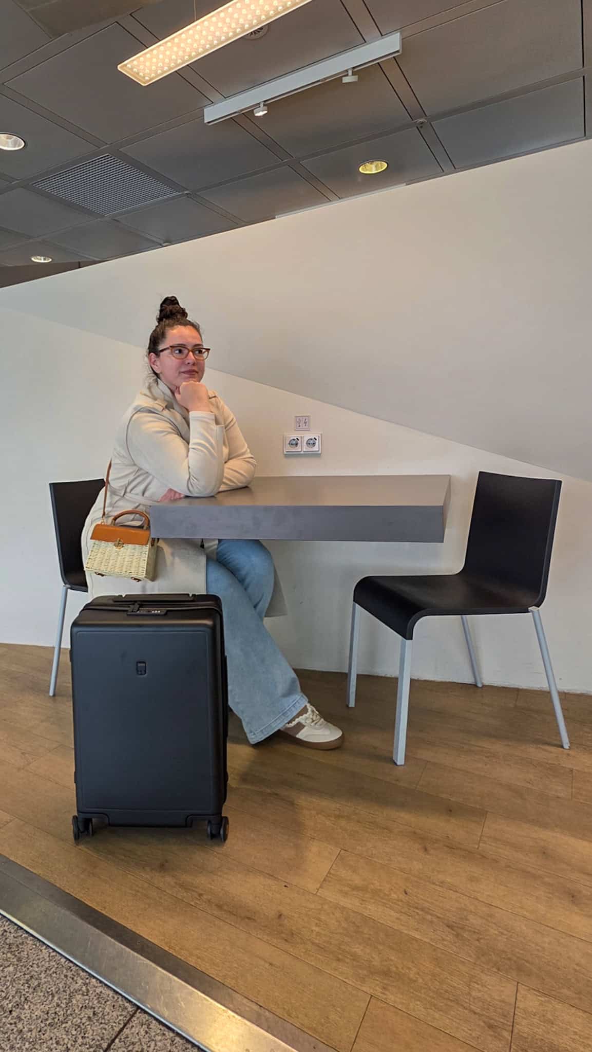 the author sitting down at the airport with her LEVEL8 luggage