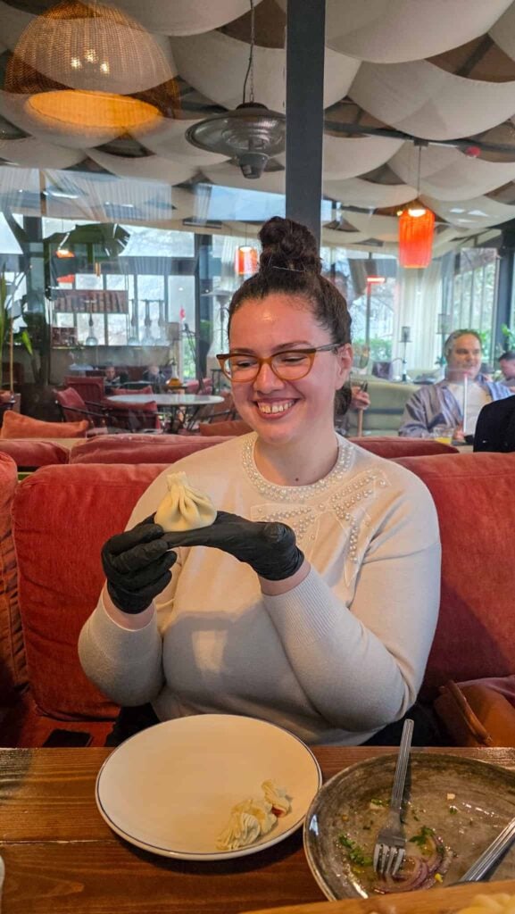 the author holding a khinkali at her cooking class in tbilisi