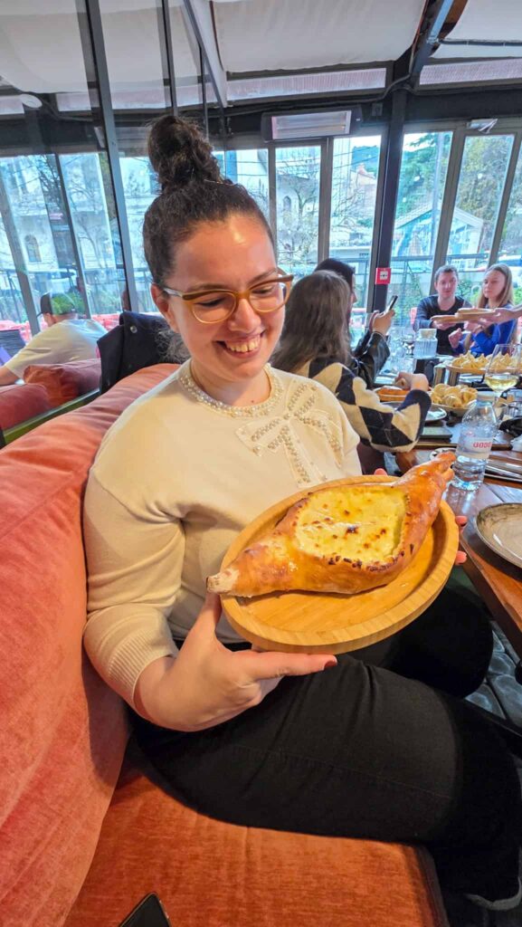the author holding the khachapuri she made at her cooking class in tbilisi