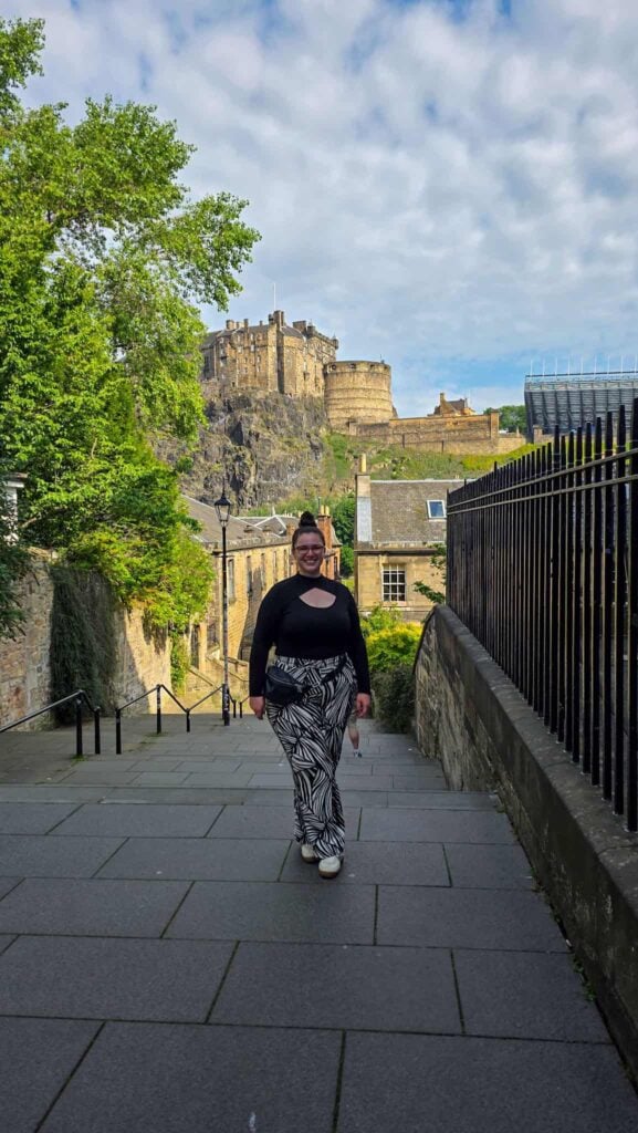 the author with a view of edinburgh castle behind her, a stop during my Edinburgh solo travel